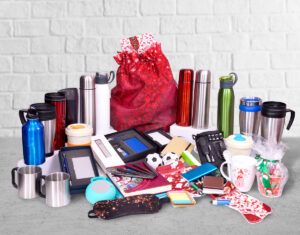 A table full of various promotional products, including water bottles, notebooks, and more.