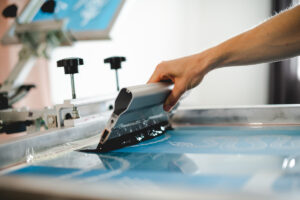 A person screen printing a t-shirt in El Paso.